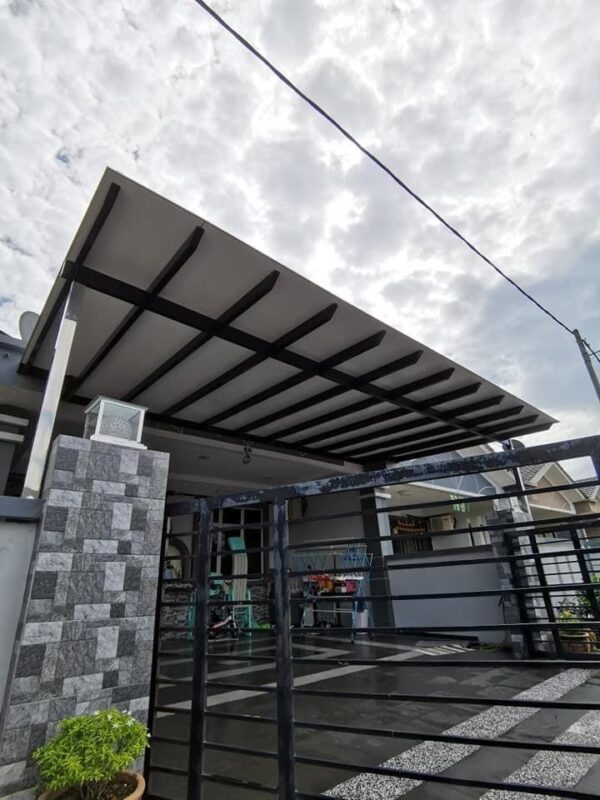 A house featuring a metal roof and a gate, complemented by an awning roof and ACP sheet and panels for modern aesthetics