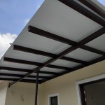A man is installing an awning roof on a house, working with ACP sheets and panels for a durable finish